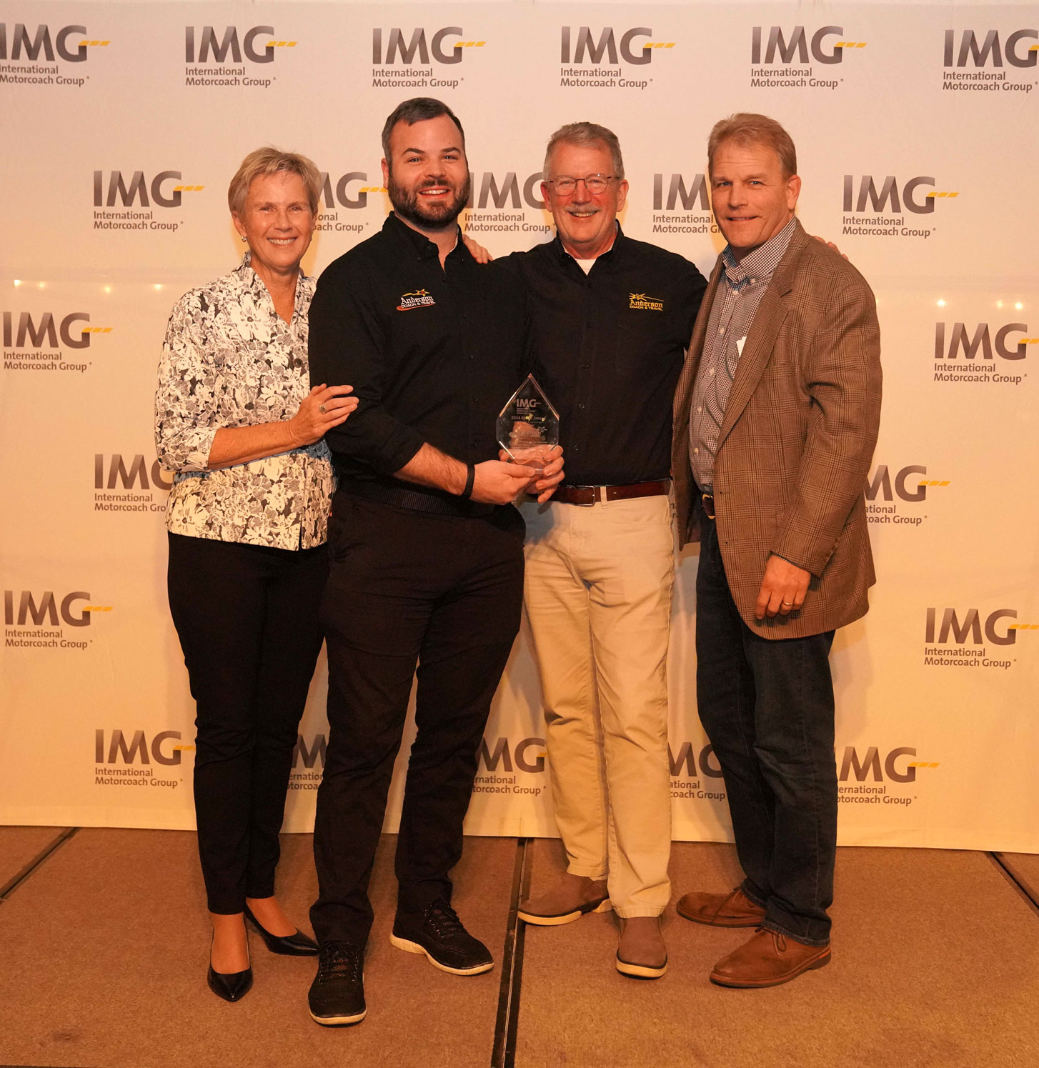 Four people with glass trophy